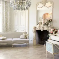 Elegancki salon w stylu wiktoriańskim: kanapa, kominek z lustrem, biały fortepian i kryształowy żyrandol tworzą luksusową atmosferę.