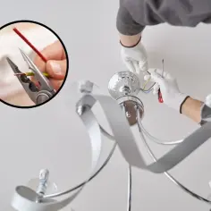 Instrukcja jak podłączyć lampę sufitową: elektryk w białych rękawiczkach łączy przewody. W kółku widać obcinanie izolacji.