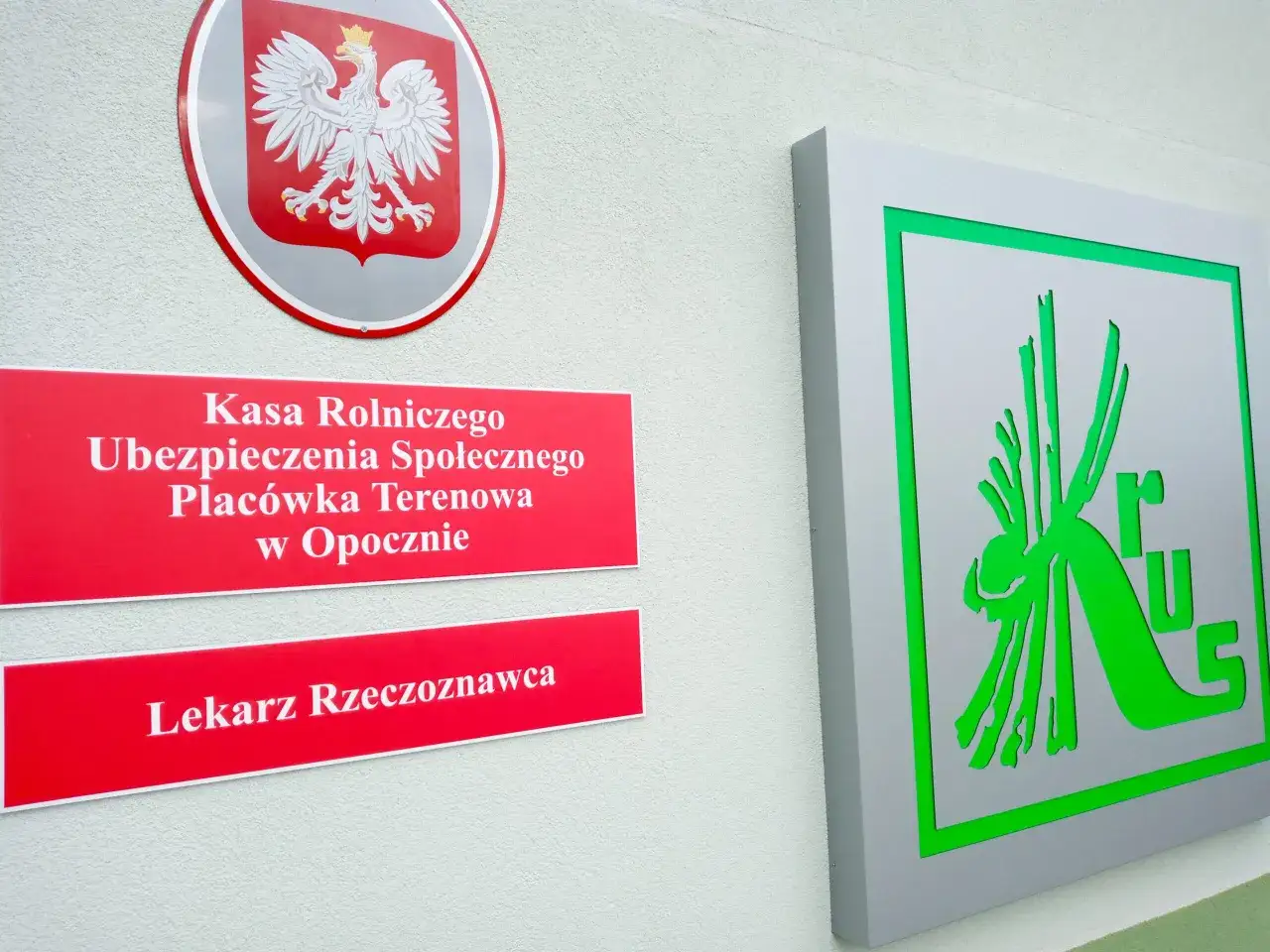 Tablica Kasy Rolniczego Ubezpieczenia Społecznego w Opocznie. Kiedy powstał KRUS? Odpowiedź znajdziesz w historii ubezpieczeń rolniczych.